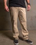 Dixxon Canada. Khaki Chino Pants. Model wearing slim-fit, straight-leg chino pants with a clean front design and dual front slash pockets.